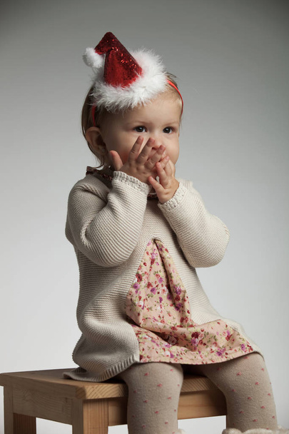ragazza con le palme sopra la bocca si aspetta Babbo Natale
 - Foto, immagini