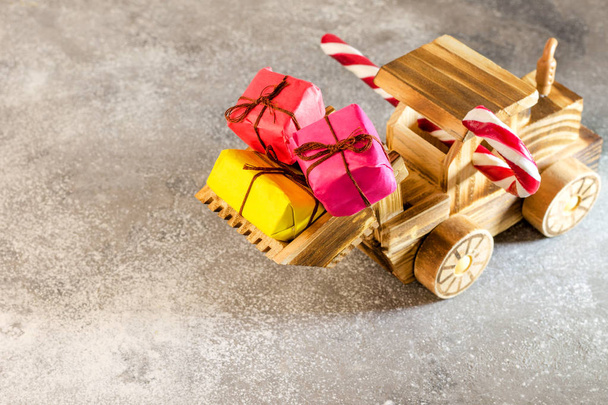 Wooden toy tractor carries Christmas presents in its bucket. The - Photo, Image