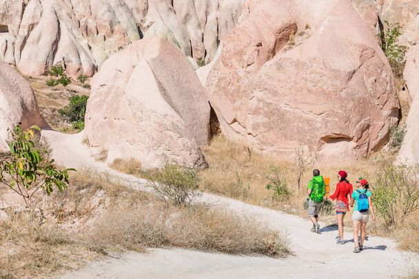 Група молодих мандрівників активний та кмітливий прогулянка серед пагорбів пустелі барвисті туф в Національний парк Каппадокії, Туреччина - Фото, зображення