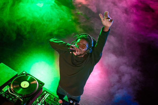 DJ με μικρόφωνο σε νυχτερινό κέντρο διασκέδασης  - Φωτογραφία, εικόνα