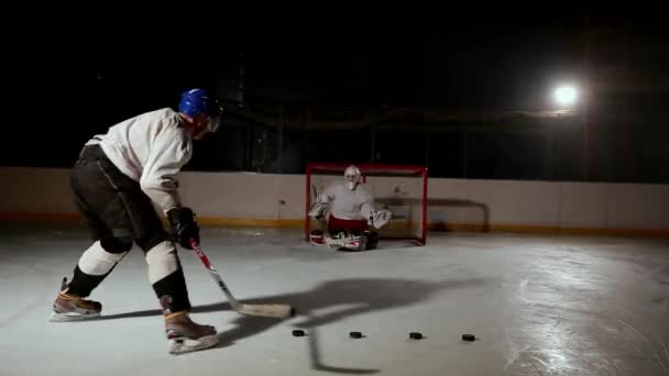 Επαγγελματική χόκεϊ παίκτης παράγει έναν πυροβολισμό στο στόχο στο ice arena. - Πλάνα, βίντεο