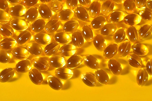 Omega-3 fish fat oil capsules on a yellow background - Photo, Image