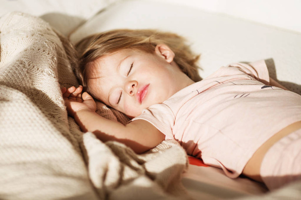 Carefree sleep little baby with a soft toy on the bed. - Photo, Image