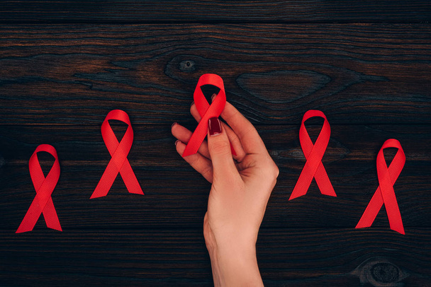 hand with red aids ribbons - Φωτογραφία, εικόνα