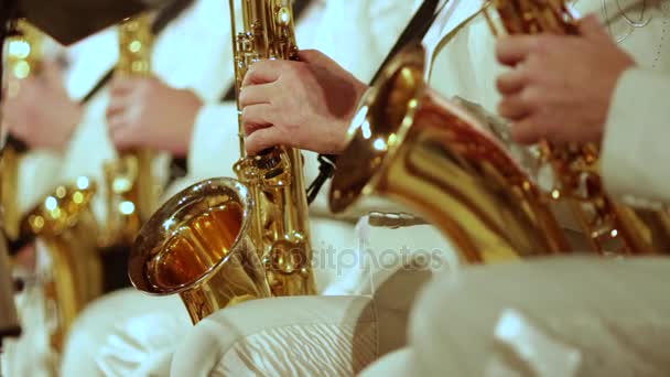 Musicisti in abiti bianchi suonano sassofoni in una band jazz. Piccolo DOF
. - Filmati, video