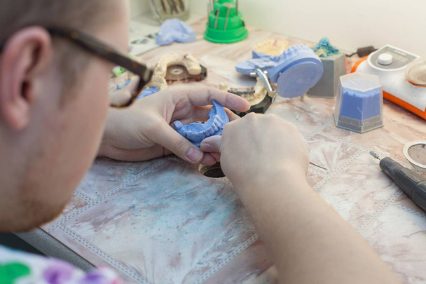 Dentist working with dental mold at clinic - Fotoğraf, Görsel