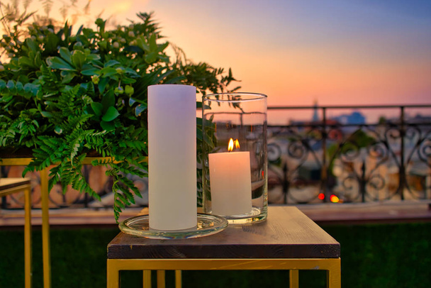 Glass candleholder on the roof of building with the view of old downtown. Romantic details of St.Valentines, wedding dinner or diwali - Fotó, kép