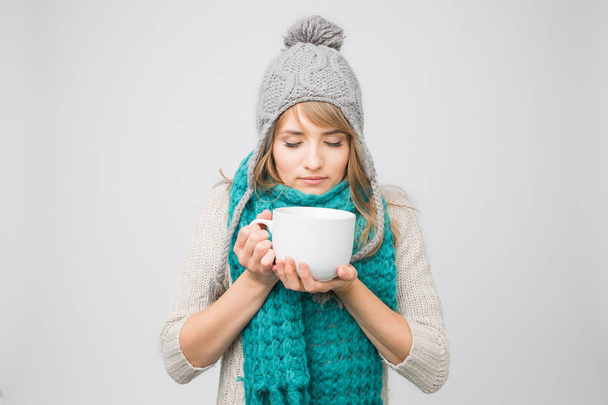 vrouw in gebreide cap drinken thee  - Foto, afbeelding