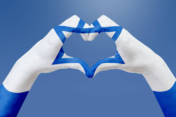 Manos bandera de Israel, forma un corazón. Concepto de símbolo del país, en el cielo azul
. - Foto, imagen