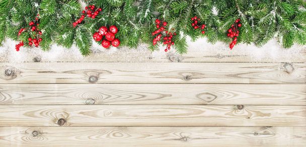 Χριστουγεννιάτικο δέντρο κλαδιά κόκκινα μούρα φόντο ξύλινη διακόσμηση - Φωτογραφία, εικόνα