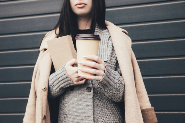 woman in sweater and coat with coffee - Foto, Bild