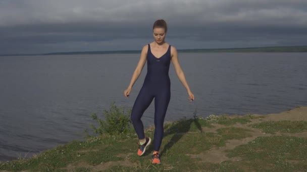 Donna attraente in abbigliamento sportivo, pratica yogi all'aperto
 - Filmati, video
