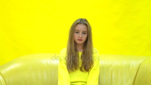 Young fresh and beautiful blond girl on yellow background - Metraje, vídeo