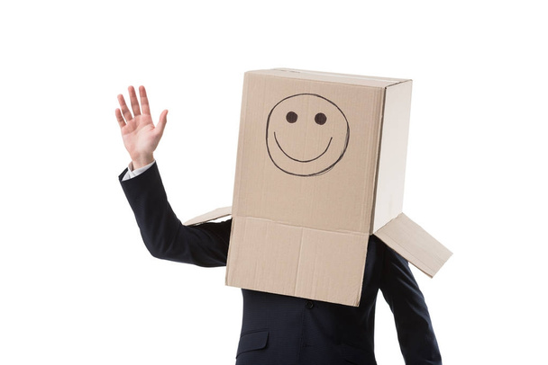 waving businessman with box on head - Foto, Imagem