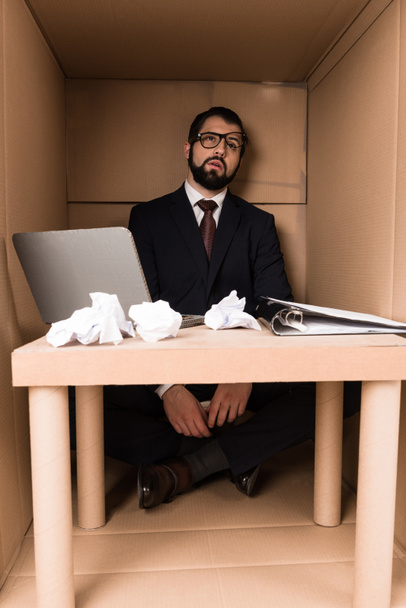 hombre de negocios agotado sentado en la caja
  - Foto, imagen