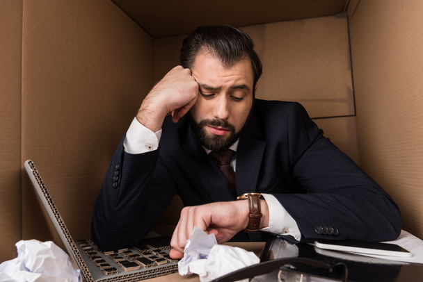 скучающий бизнесмен смотрит на часы
 - Фото, изображение