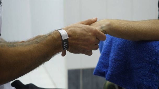 Boxtrainer oder Manager wickeln Hände eines Boxers aus nächster Nähe flache Schärfentiefe ein - Vorbereitung auf Boxkampf - Arzt wickelt mögliche gebrochene oder gebrochene Hand einer verletzten Person ein - Foto, Bild