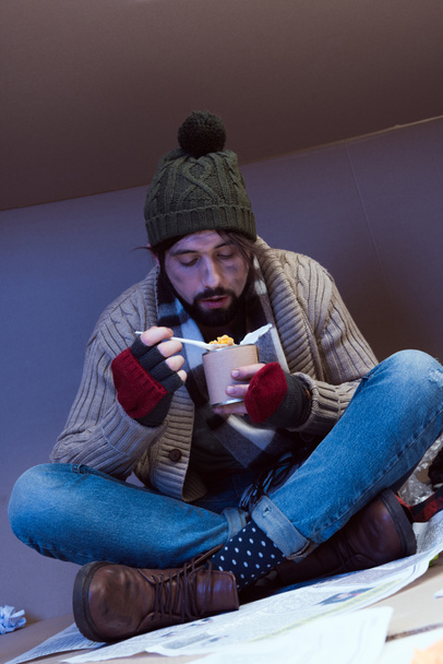 hombre sin hogar comiendo comida enlatada
 - Foto, Imagen