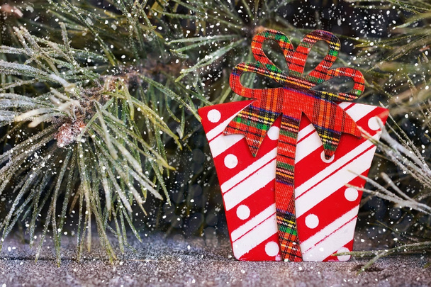 Weihnachtsspielzeug auf einem Hintergrund aus schneebedeckten Tannenzweigen - Foto, Bild