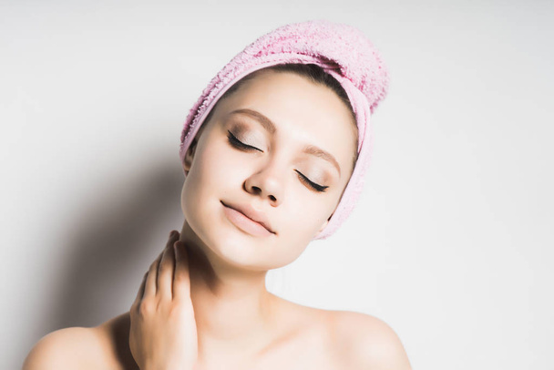 Atrakcyjna dziewczyna z czystą skórę i różowy ręcznik na głowie stwarza - Zdjęcie, obraz