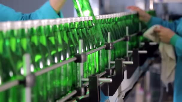 Um funcionário da linha de produção limpa garrafas de vidro verde para água mineral
 - Filmagem, Vídeo