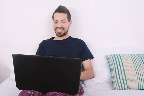 Man using laptop in bed. - Foto, immagini