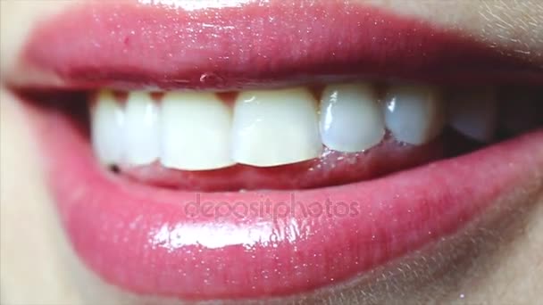 Close-up van vrouwelijke lippen met roze glans. Vrouw glimlachen en lachen. - Video