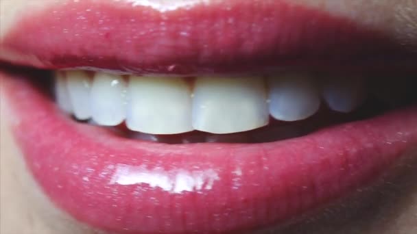 Boca sonriente abierta femenina con labios sexy brillo rosa y lengua. Primer plano.
 - Metraje, vídeo