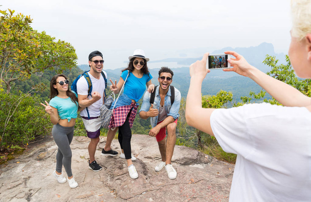Inteligentny telefon komórkowy przejęcia zdjęcie wesoły grupy turystyczne z plecaka krajobraz od góry, ludzie pozowanie - Zdjęcie, obraz