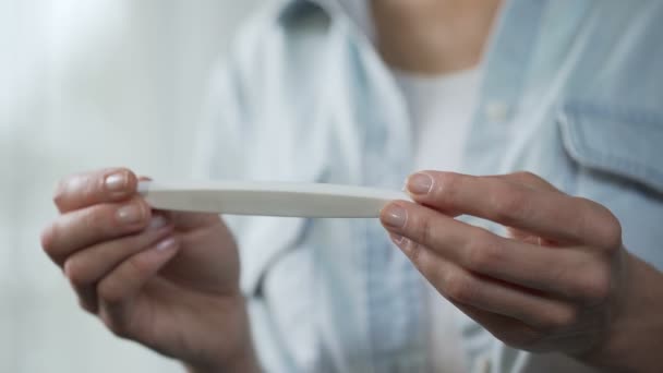 Female holding negative pregnancy test in hands, demonstrating before camera - Footage, Video