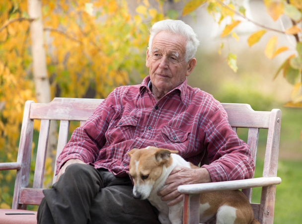 Starý muž se psem na lavičce v parku - Fotografie, Obrázek