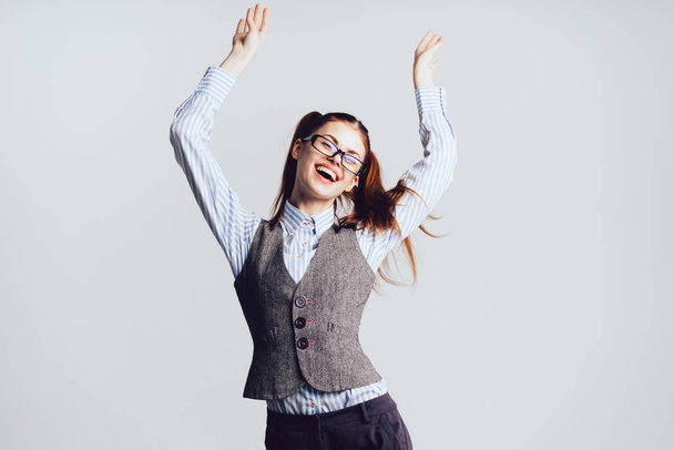 Girl student with glasses jumping for joy on a white background - Photo, image