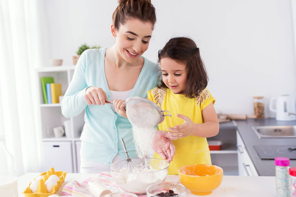 happy mother and daughter baking at home - Φωτογραφία, εικόνα