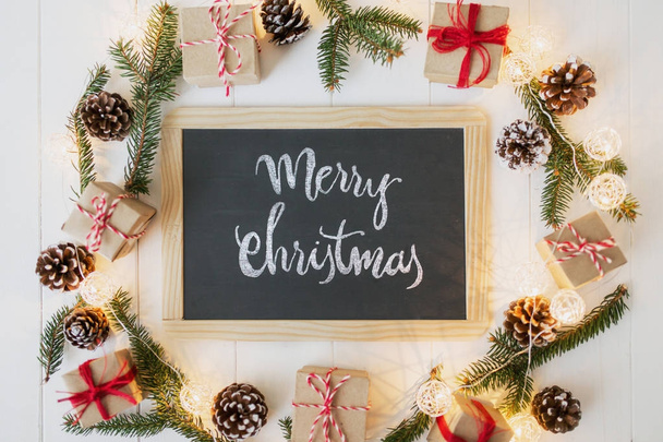 Kerstmis achtergrond met bord en inscriptie, vuren, doos van de gift en scroll op houten planken. - Foto, afbeelding