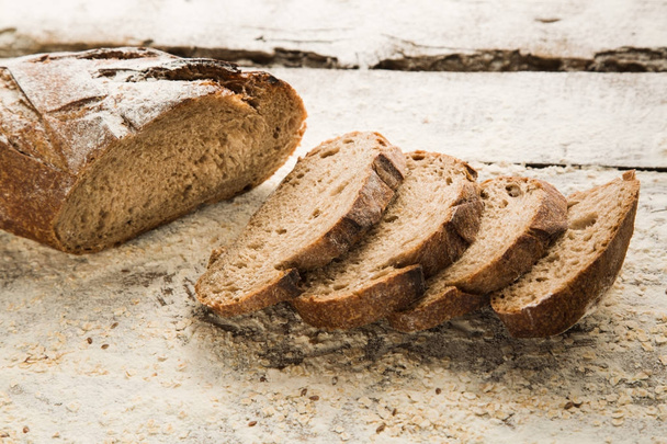 Zelfgemaakte bruin brood gesneden op een snijplank. - Foto, afbeelding