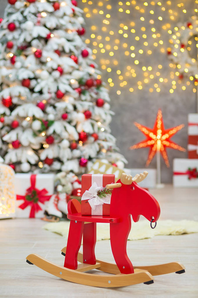 Christmas studio decorations wonderful idea mainly white and red New Year tree with snow and plenty presents under Amazing LED lights bake and huge paper star. - Foto, Imagen