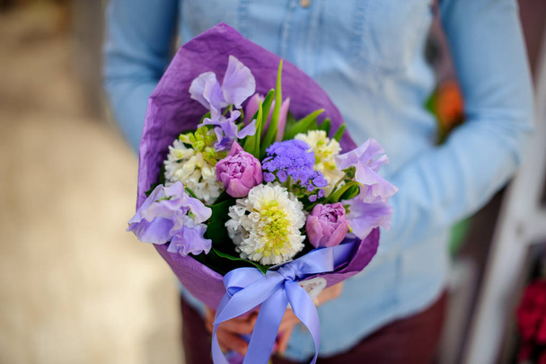 Florist holding a beautiful and cute purple bouquet of flowers - Фото, зображення