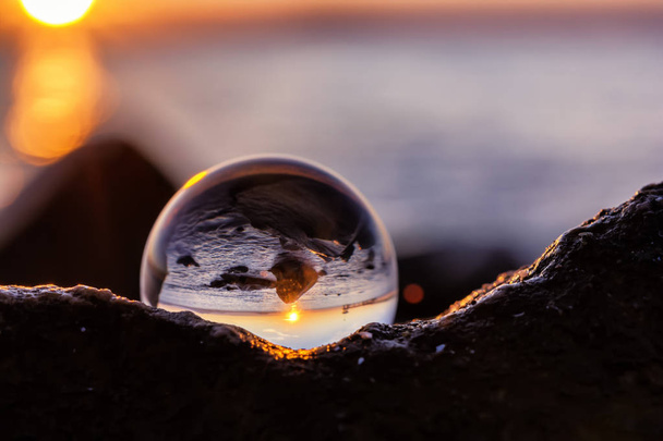 Отражение хрустального шара на берегу в свете восхода солнца
. - Фото, изображение