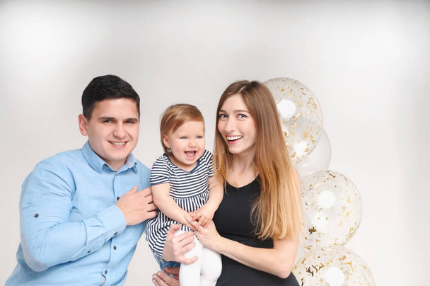 Portrait of happy mother, father and daughter on her first birthday party - Photo, Image
