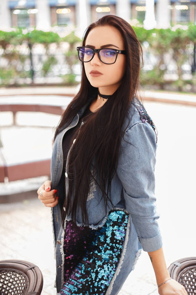 Mujer joven y elegante con anteojos negros y chaqueta de mezclilla azul
 - Foto, Imagen