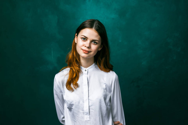 cute girl in a white blouse smiling looking into the camera, on a green background, isolated - Fotoğraf, Görsel