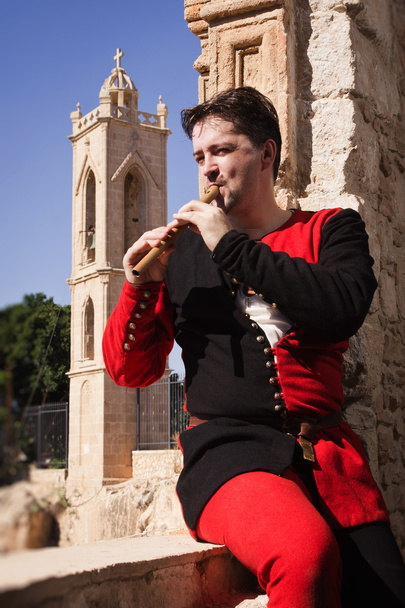 L'uomo in abito medievale suona un flauto
 - Foto, immagini