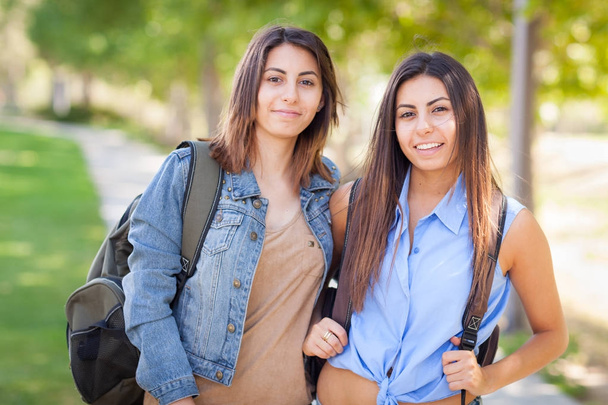 Dvě krásné mladé etnické dvojčata s batohy, procházky venku - Fotografie, Obrázek
