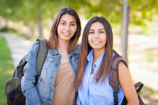 Dvě krásné mladé etnické dvojčata s batohy, procházky venku - Fotografie, Obrázek