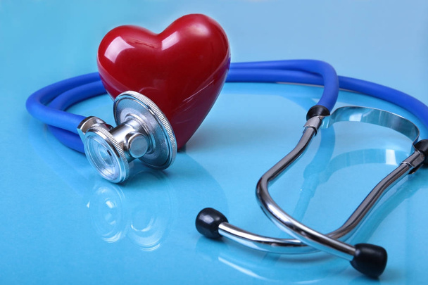 Medical stethoscope and red heart isolated on mirror background. - Photo, image