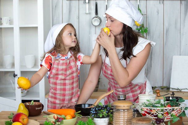 Мать и дочь готовят ужин вместе на кухне. Портраи
 - Фото, изображение