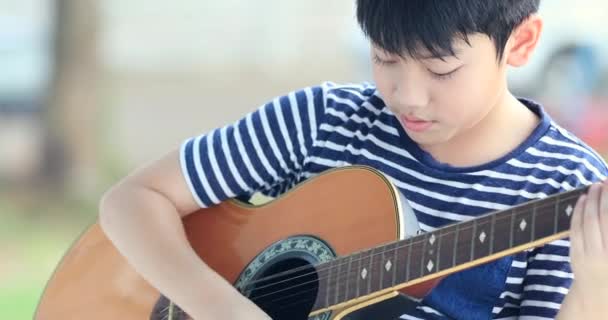Aziatische jongetje speelt de gitaar - Video