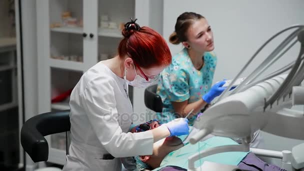 歯科医と看護師が患者の男性の歯を修復します。ドリルの歯と虫歯とシールを削除する bormashenko の使用 - 映像、動画