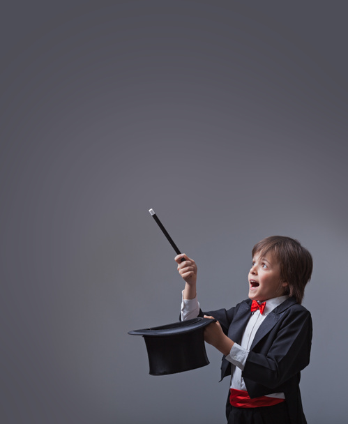 Magician boy performing with magic wand and hard hat - Photo, Image