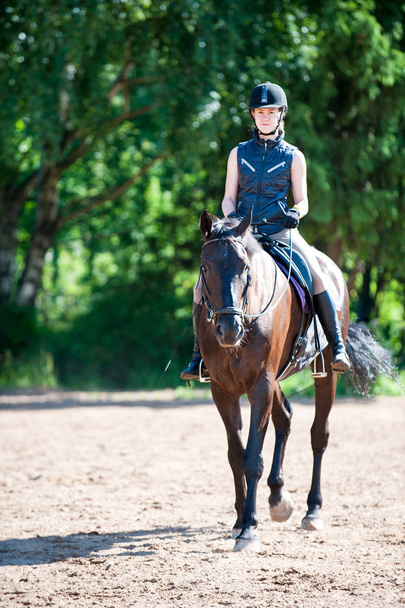 Jovem adolescente cavalgando na escola equestre
 - Foto, Imagem